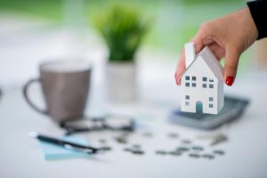 Homeowner calculating home equity and mortgage balance using financial documents and a calculator.